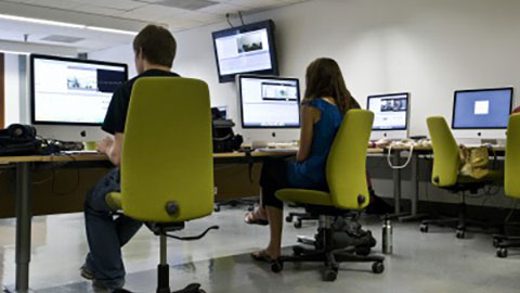 Two students working at machintosh computers.