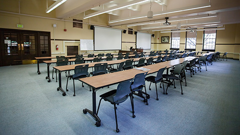 Large empty classroom with moveable tables and chairs.