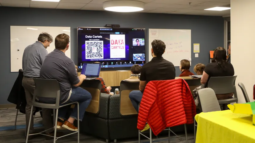 a group around a large screen for a virtual lecture