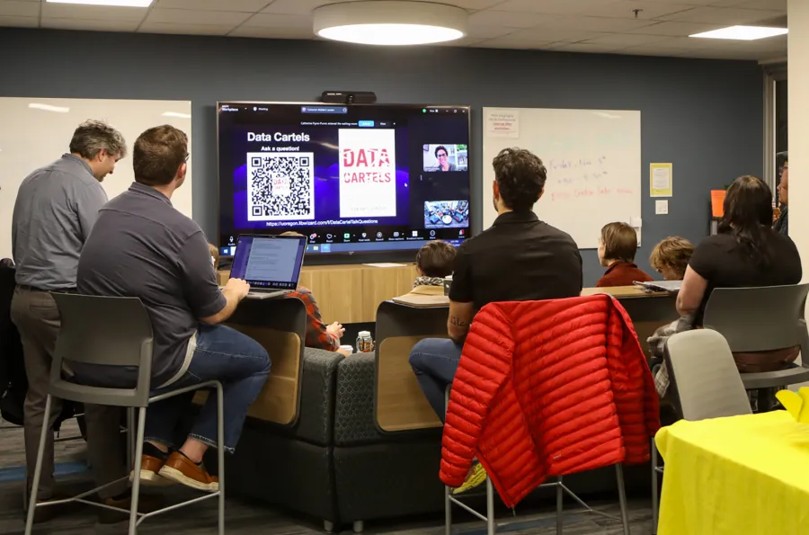 a group around a large screen for a virtual lecture